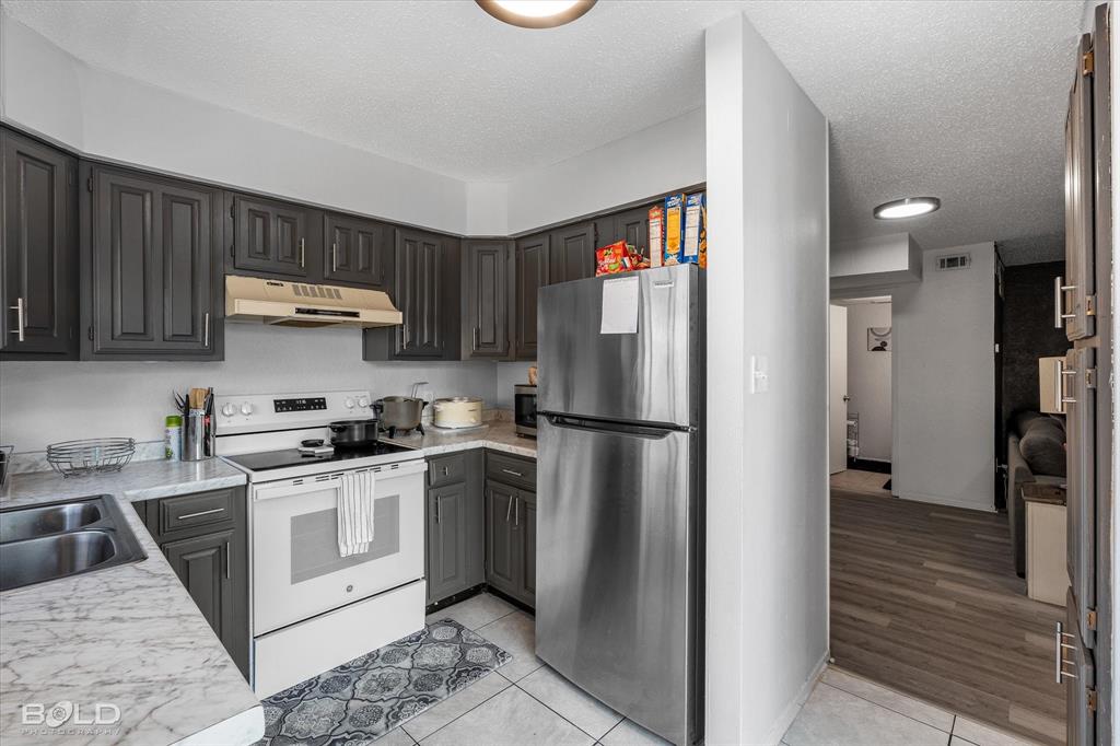3100 Fairfield Avenue, Unit 10D Shreveport, LA 71104 - Photo 17 of 28 a kitchen with a stove a refrigerator and a sink with wooden floor