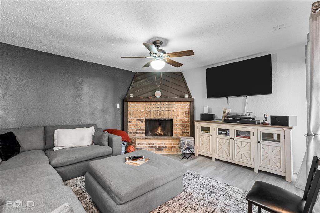 3100 Fairfield Avenue, Unit 10D Shreveport, LA 71104 - Photo 9 of 28 a living room with furniture a fireplace and a flat screen tv