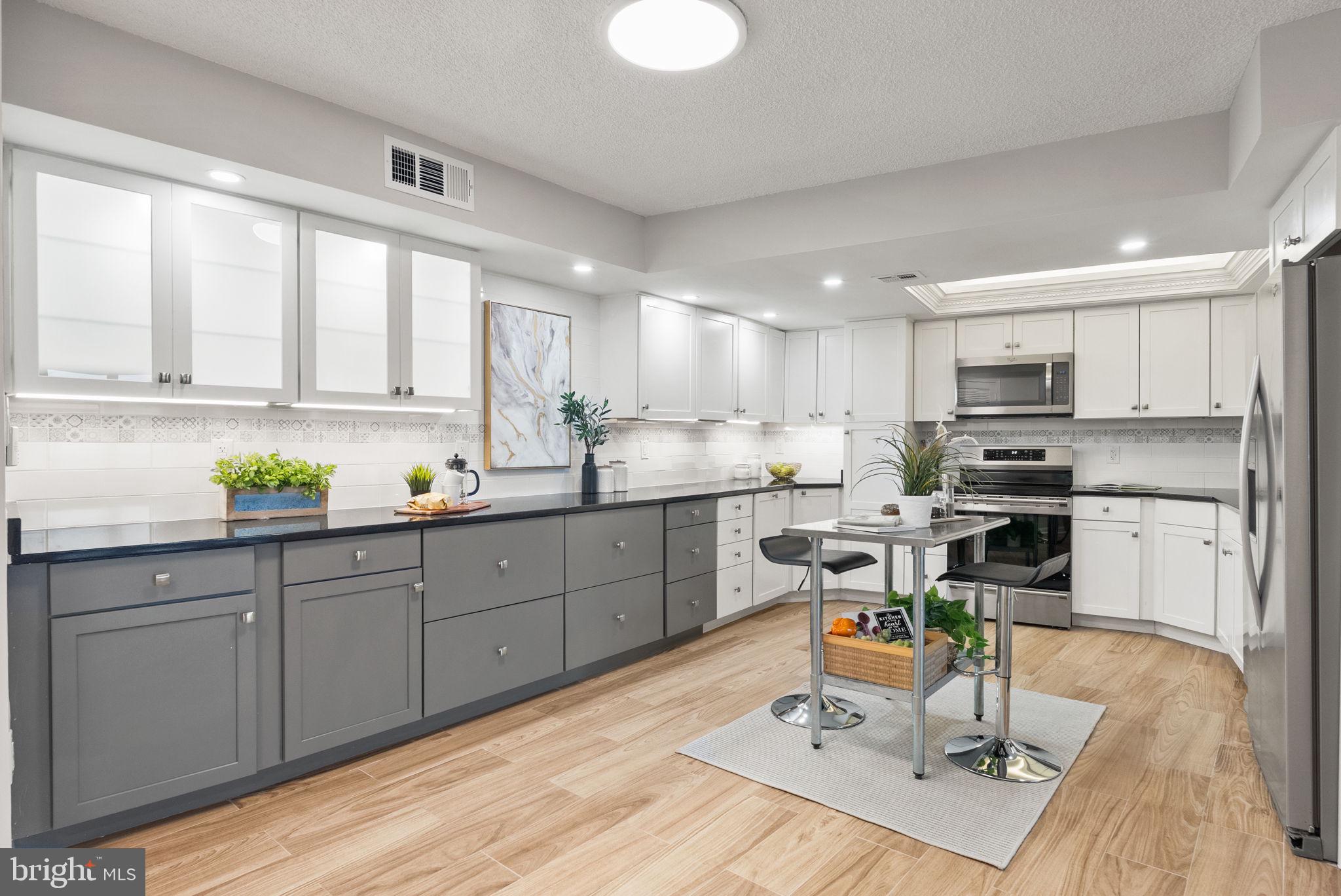 1101 South Arlington Ridge Road, Unit 313 Arlington, VA 22202 - Photo 12 of 59 a kitchen with a refrigerator a stove cabinets and a dining table with wooden floor