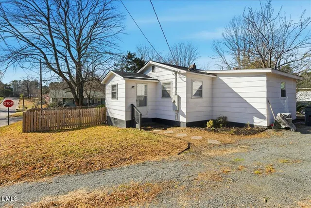 a view of a yard with wooden fence