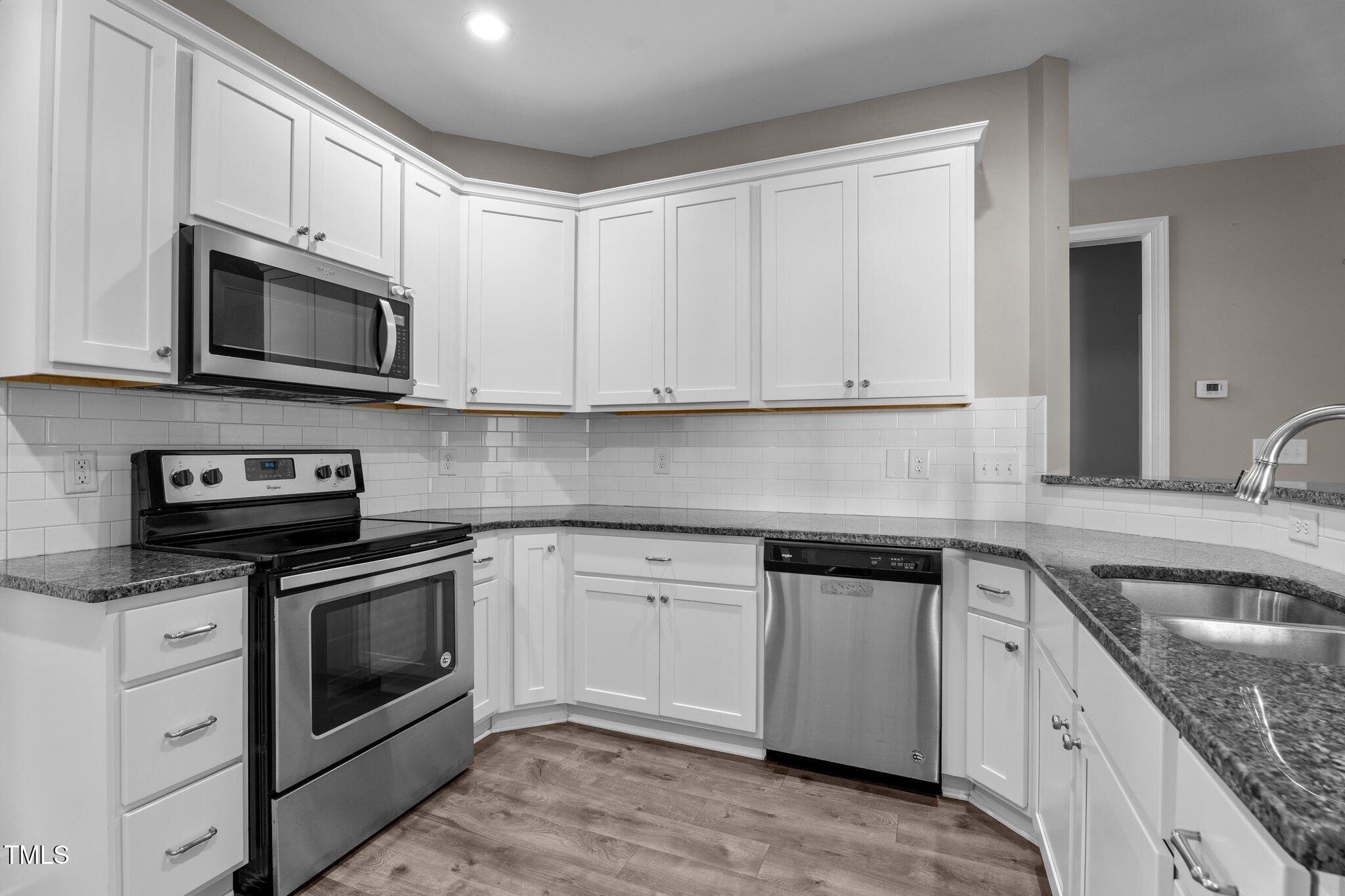 46 Trusting Lane Middlesex, NC 27557 - Photo 20 of 35 a kitchen with stainless steel appliances granite countertop grey cabinets a stove a sink and dishwasher