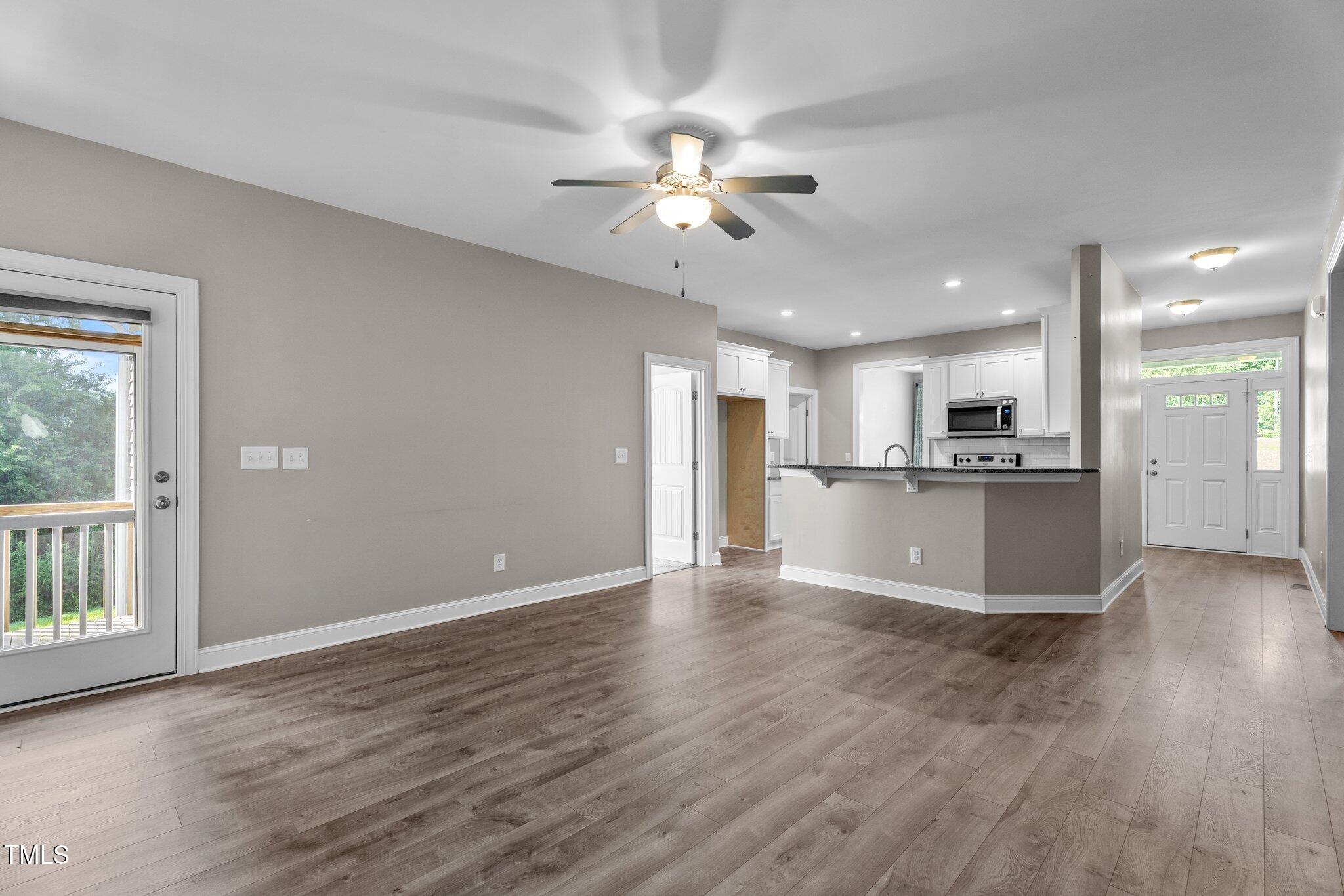 46 Trusting Lane Middlesex, NC 27557 - Photo 24 of 35 a view of an empty room with wooden floor and a kitchen