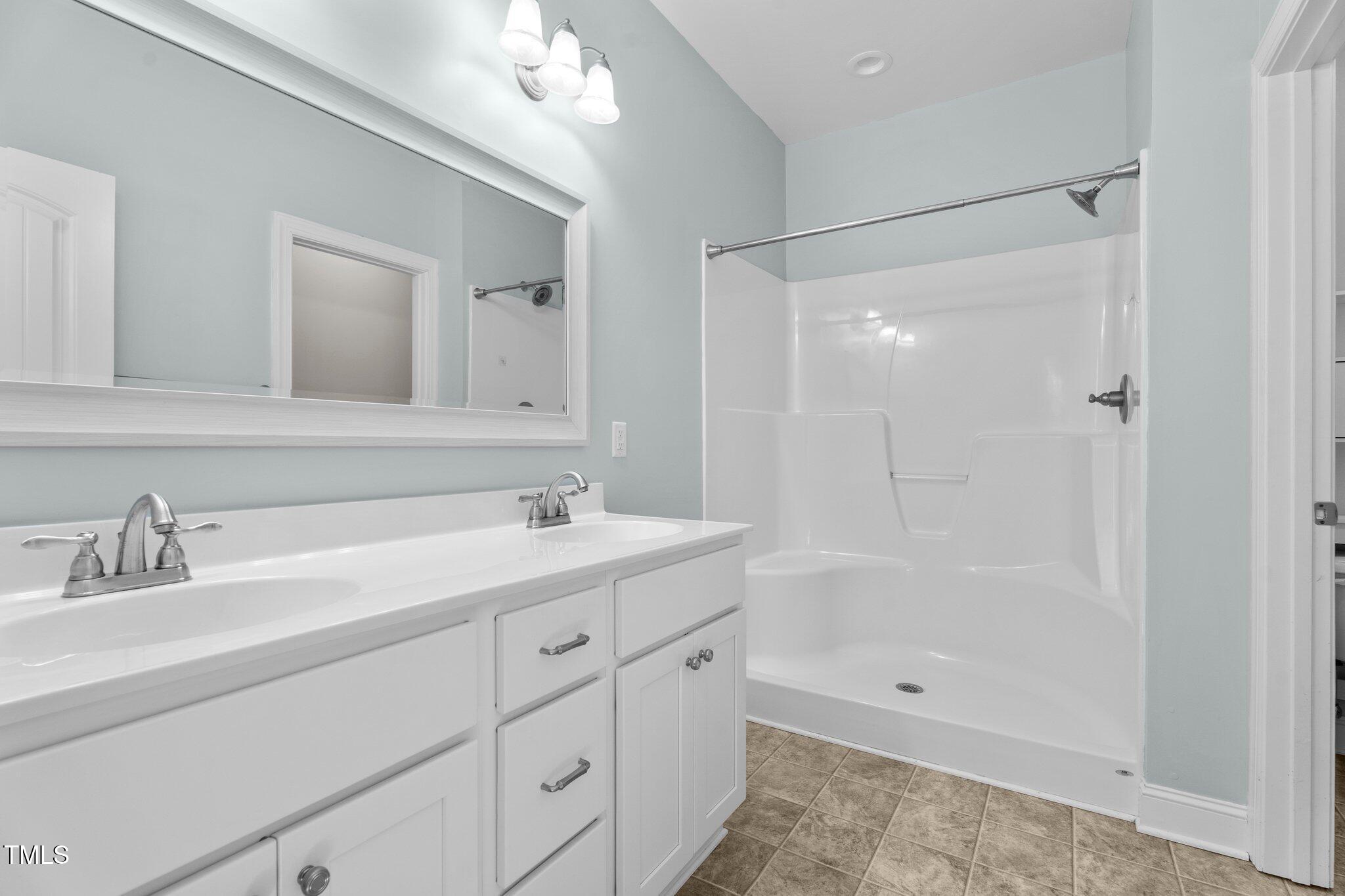 46 Trusting Lane Middlesex, NC 27557 - Photo 27 of 35 a bathroom with a shower sink vanity and mirror