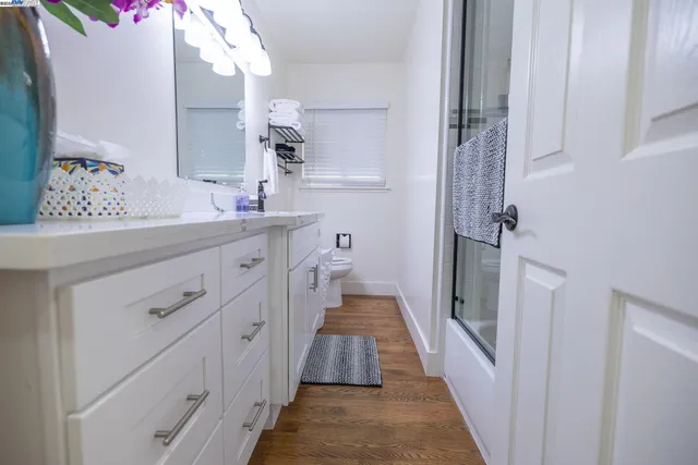 a bathroom with a granite countertop sink a large mirror and shower