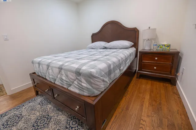 a bedroom with a bed and wooden floor
