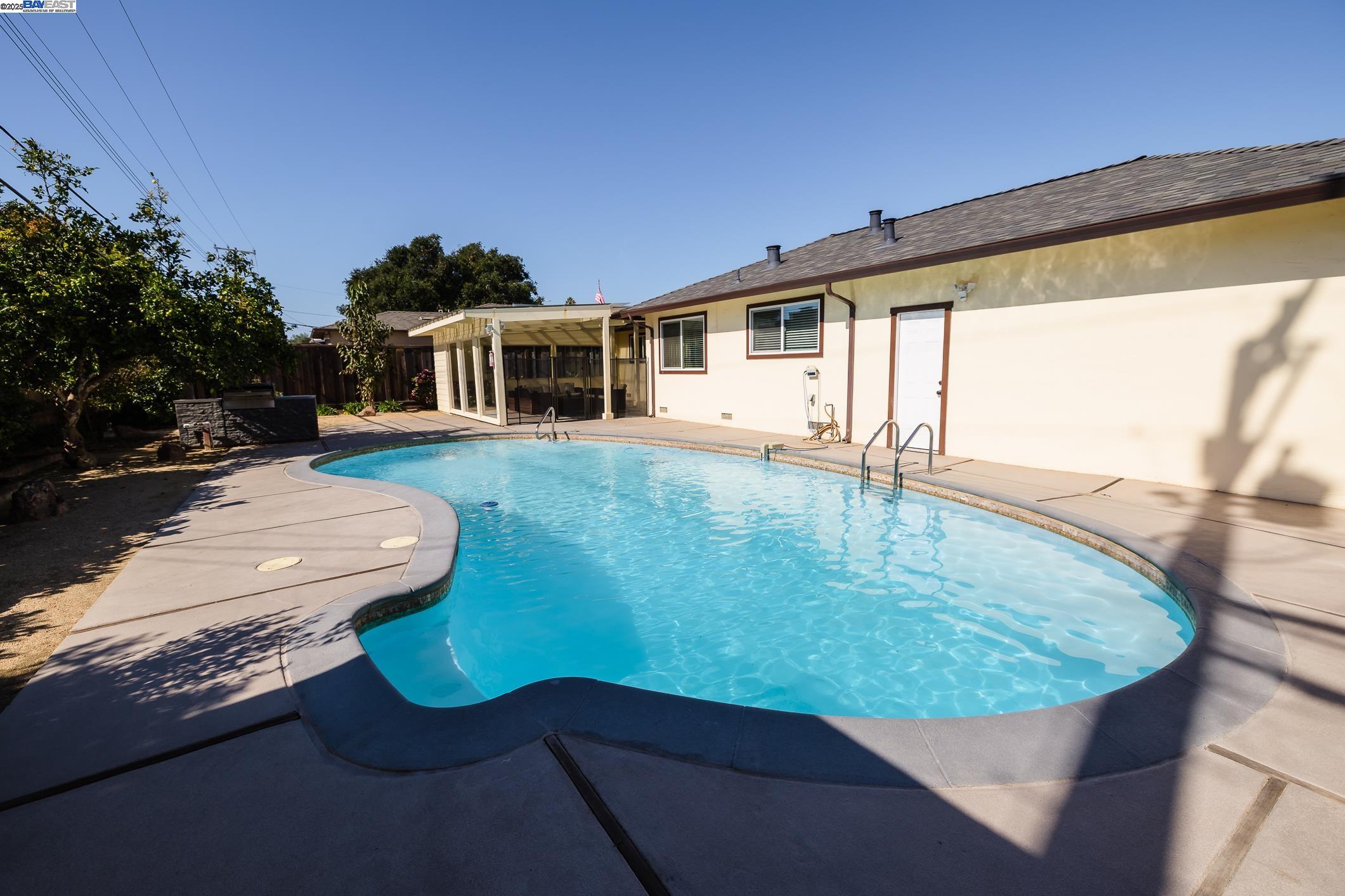 767 Lemos Avenue Salinas, CA 93901 - Photo 52 of 60 Enjoy a spacious 10-ft deep pool with a wide concrete deck, open yard, and plenty of sun—perfect for swimming, relaxing, or hosting. A great outdoor space ready for fun and comfort.
