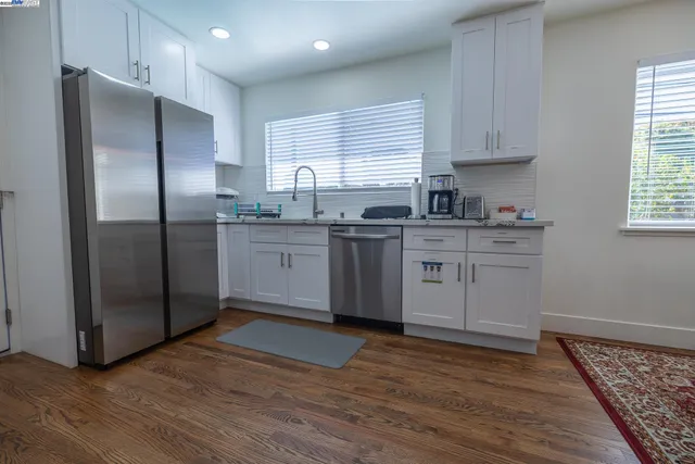 a kitchen with granite countertop white cabinets and appliances