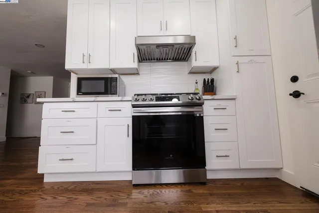 a kitchen with a sink a refrigerator and a stove top oven