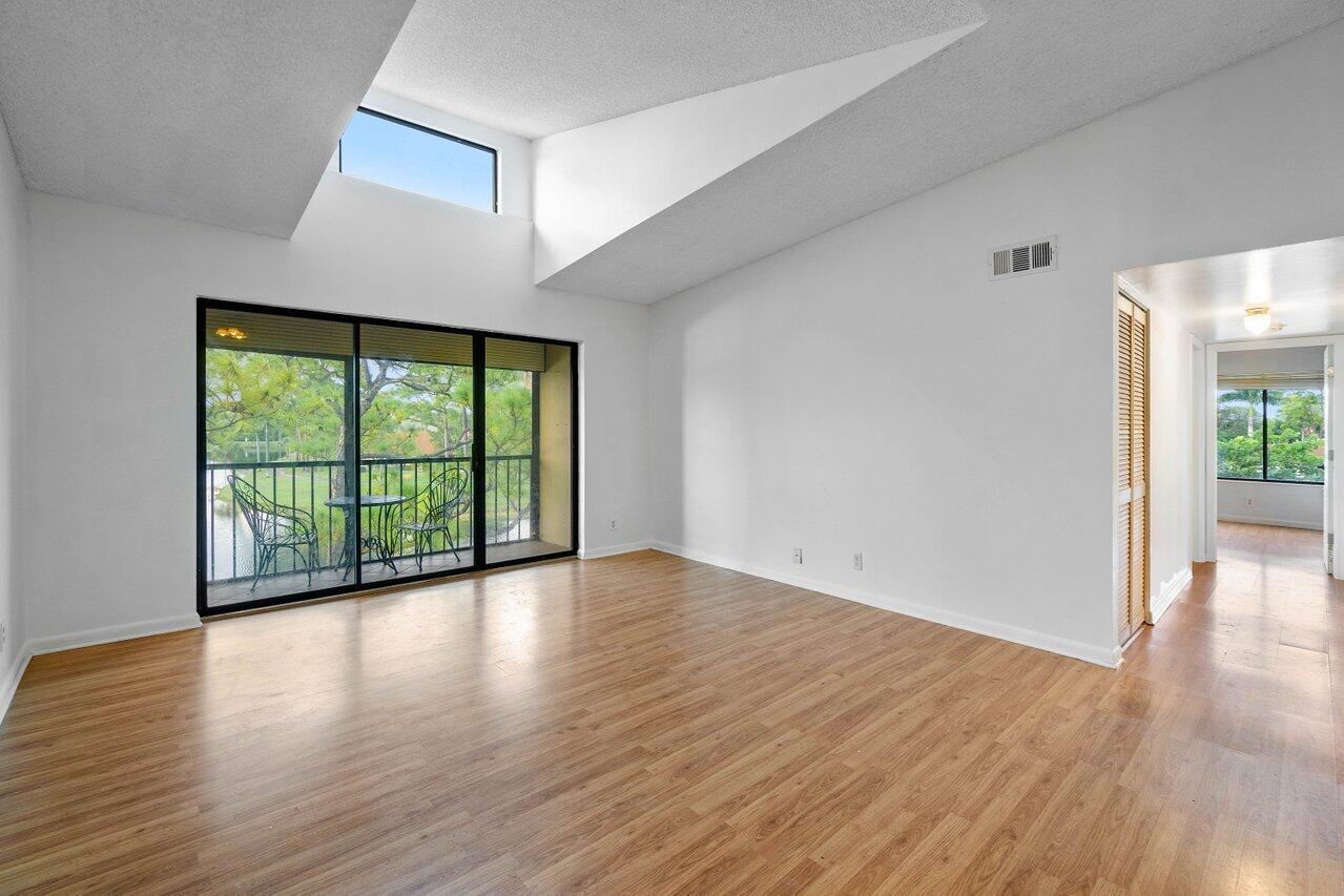 603 Sea Pine Way, Unit E3 Greenacres, FL 33415 - Photo 3 of 22 a view of an empty room with wooden floor and a window