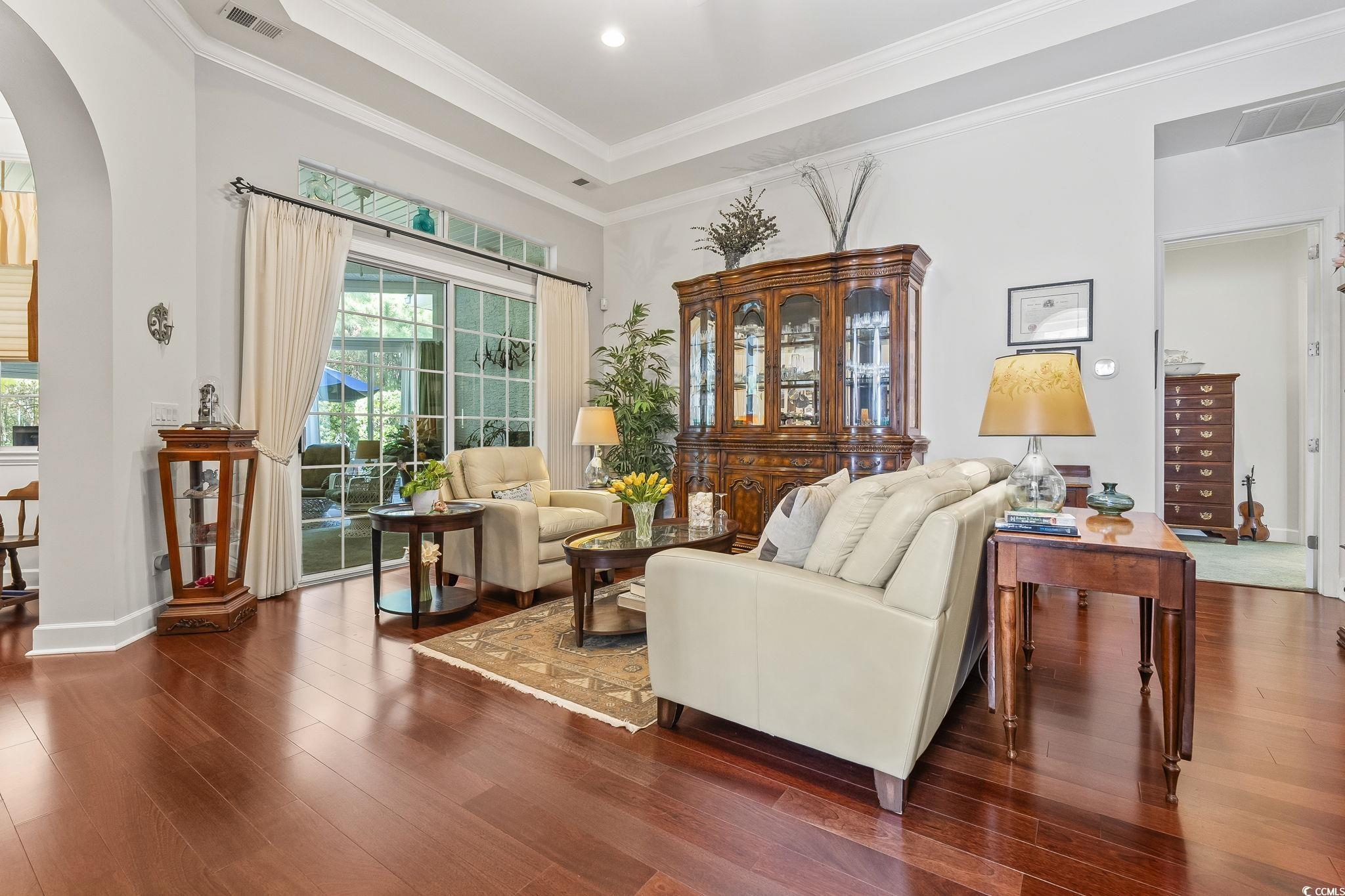 209 Sugar Loaf Lane Murrells Inlet, SC 29576 - Photo 5 of 37 Living area with arched walkways, crown molding, plenty of natural light, wood finished floors, and a raised ceiling
