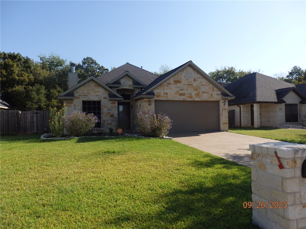 3717 Dove Crossing Lane College Station, TX 77845 - Photo 1 of 27 View of front facade with concrete driveway, stone siding, a chimney, and an attached garage