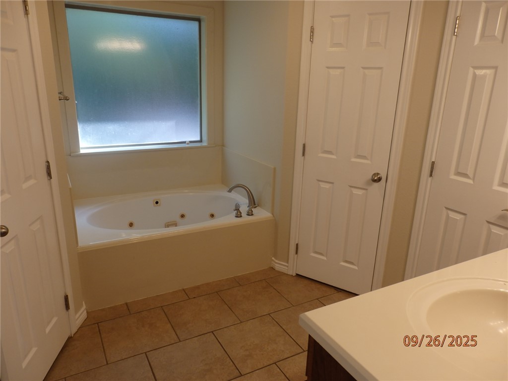 3717 Dove Crossing Lane College Station, TX 77845 - Photo 11 of 27 Full bath featuring vanity, a jetted tub, and light tile patterned floors
