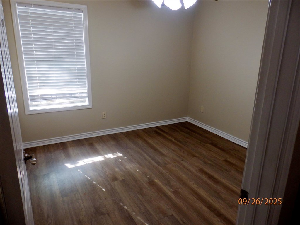 3717 Dove Crossing Lane College Station, TX 77845 - Photo 15 of 27 Unfurnished room featuring baseboards and dark wood-style flooring