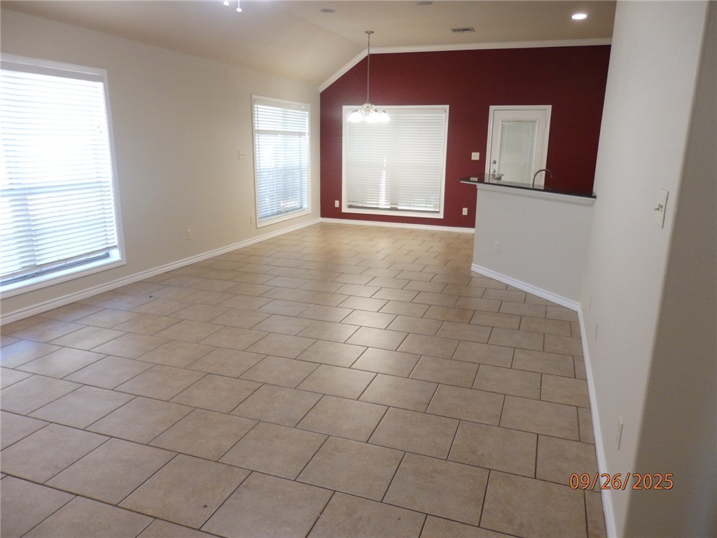 3717 Dove Crossing Lane College Station, TX 77845 - Photo 3 of 27 Spare room featuring vaulted ceiling, a chandelier, and light tile patterned floors
