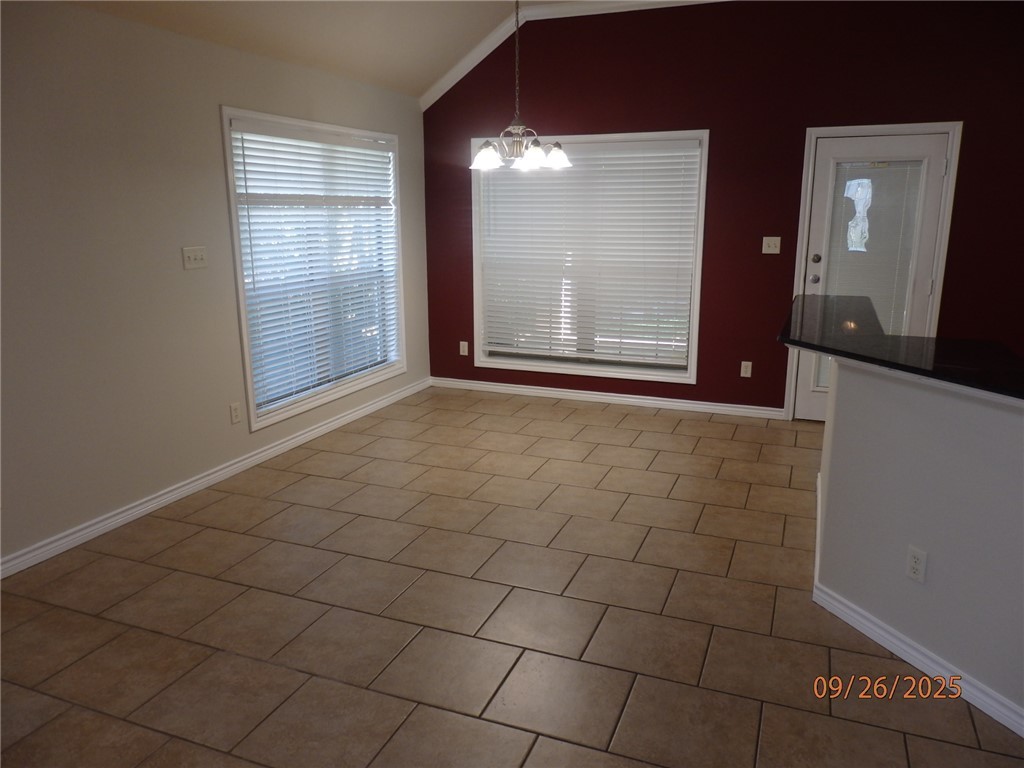 3717 Dove Crossing Lane College Station, TX 77845 - Photo 5 of 27 Unfurnished dining area featuring vaulted ceiling, a chandelier, and light tile patterned flooring