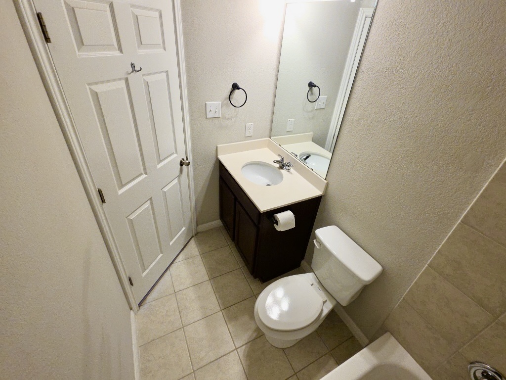 13208 Mariscan Street Manchaca, TX 78652 - Photo 16 of 31 Bathroom with vanity, a textured wall, and light tile patterned floors