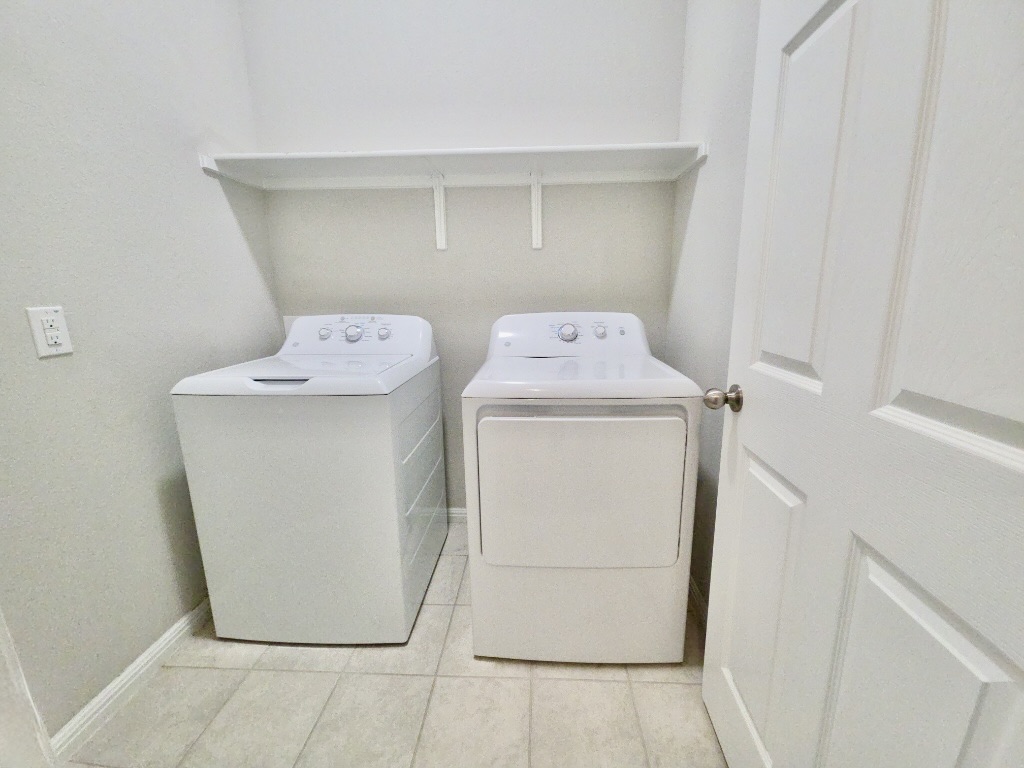 13208 Mariscan Street Manchaca, TX 78652 - Photo 19 of 31 Laundry room with washing machine and clothes dryer and light tile patterned flooring