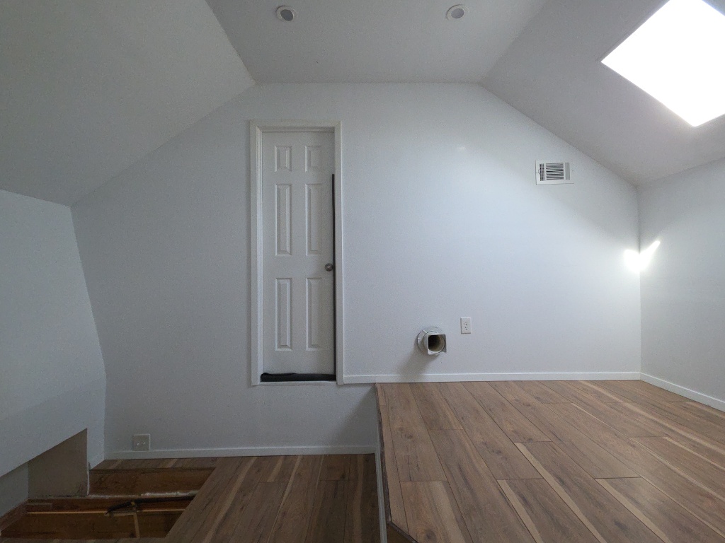 13208 Mariscan Street Manchaca, TX 78652 - Photo 24 of 31 Additional living space with lofted ceiling, dark wood-type flooring, and a skylight