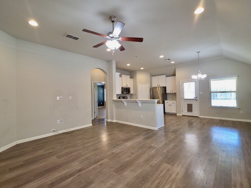 13208 Mariscan Street Manchaca, TX 78652 - Photo 3 of 31 living room with hanging lights, arched walkways, a ceiling fan, dark wood-style floors, and lofted ceiling
