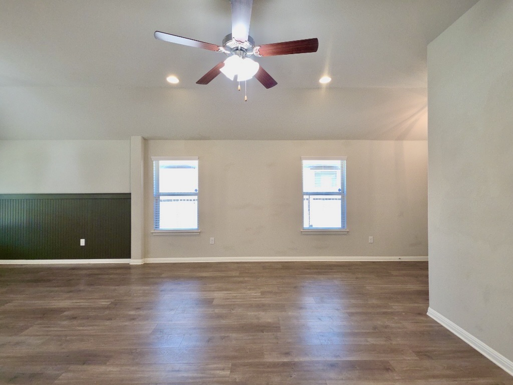 13208 Mariscan Street Manchaca, TX 78652 - Photo 4 of 31 Living room with lofted ceiling, dark wood-style flooring, ceiling fan, plenty of natural light, and wainscoting