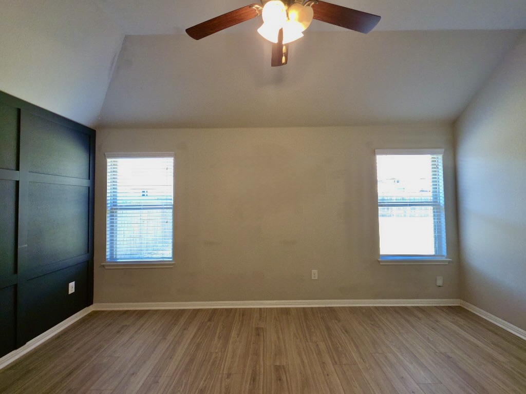 13208 Mariscan Street Manchaca, TX 78652 - Photo 9 of 31 Primary room with vaulted ceiling, wood finished floors, and a ceiling fan