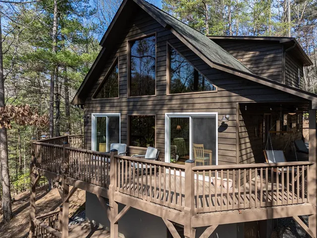 an aerial view of residential house with outdoor space and trees all around