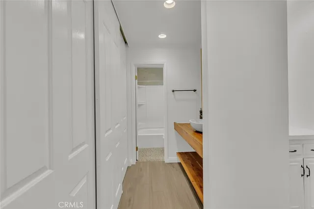 a hallway with wooden floor and stairs