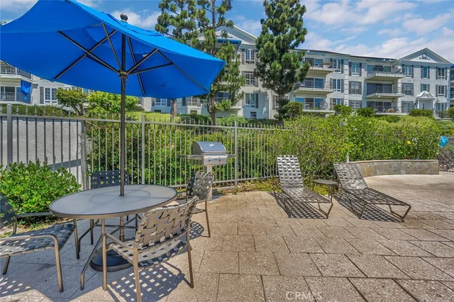 a view of a patio with table and chairs under an umbrella