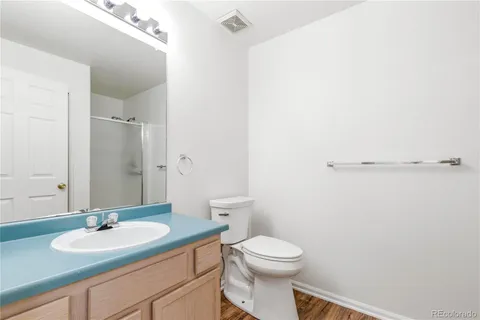 a bathroom with a granite countertop sink a toilet and a mirror