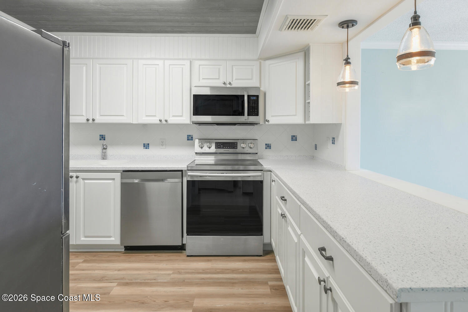 3100 Southeast Pruitt Road, Unit 104 Port St. Lucie, FL 34952 - Photo 12 of 32 a kitchen with white cabinets and stainless steel appliances