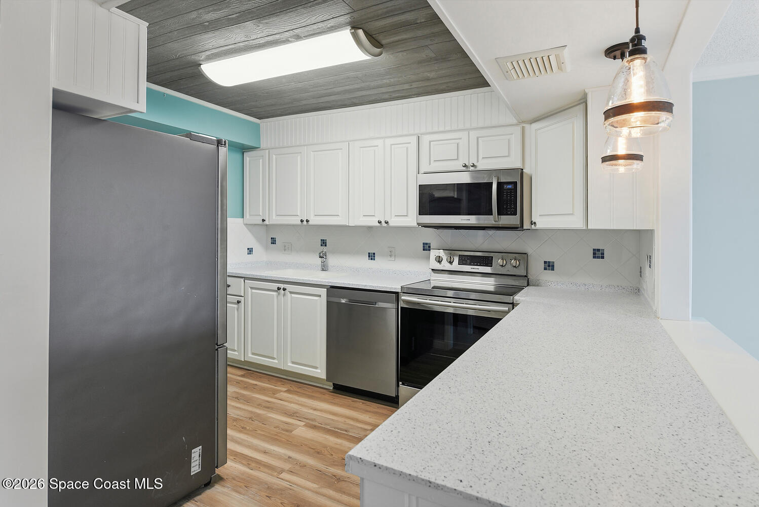 3100 Southeast Pruitt Road, Unit 104 Port St. Lucie, FL 34952 - Photo 14 of 32 a kitchen with a stove top oven a sink and a refrigerator