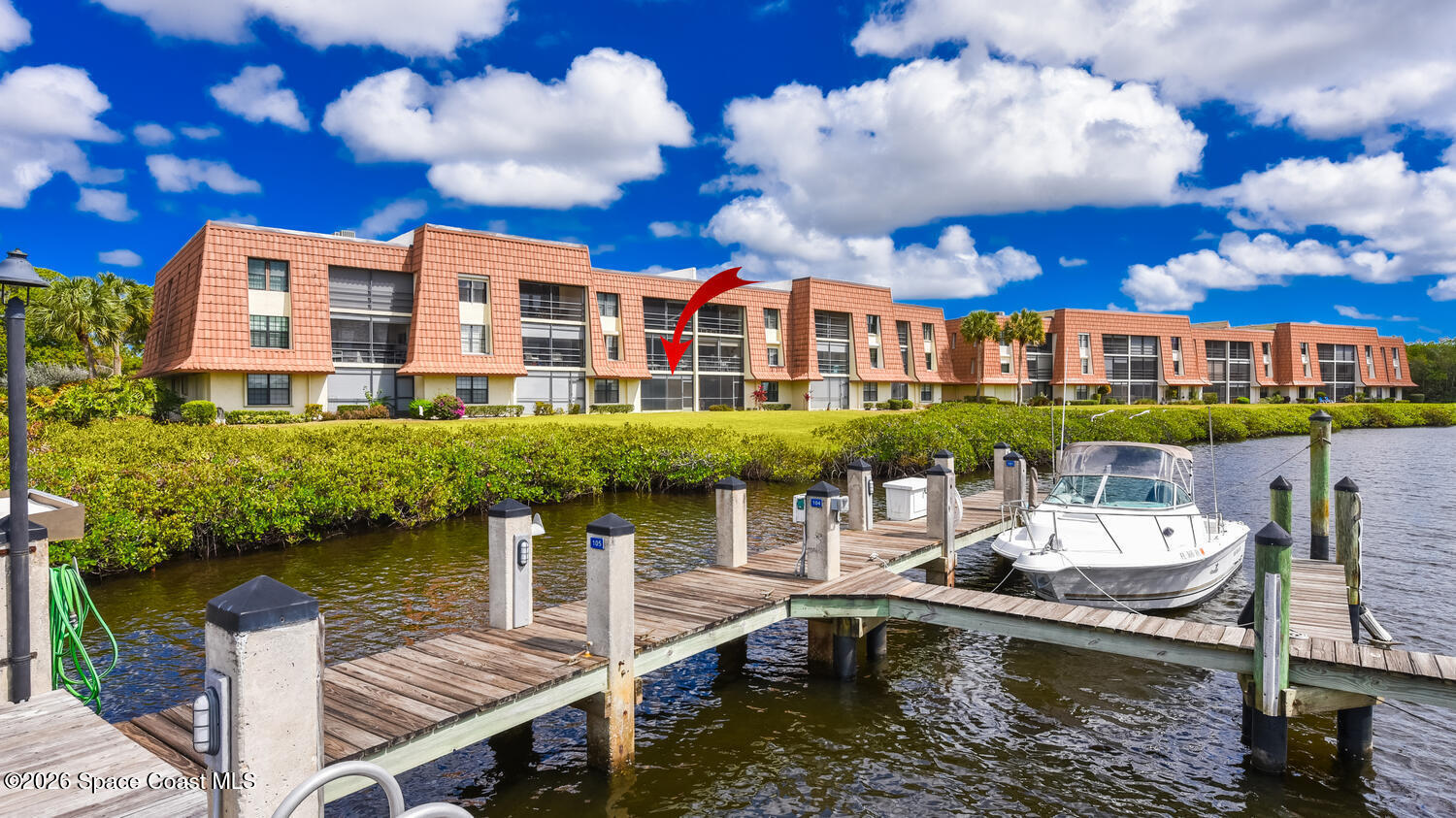 3100 Southeast Pruitt Road, Unit 104 Port St. Lucie, FL 34952 - Photo 2 of 32 a view of a lake with a patio and a garden