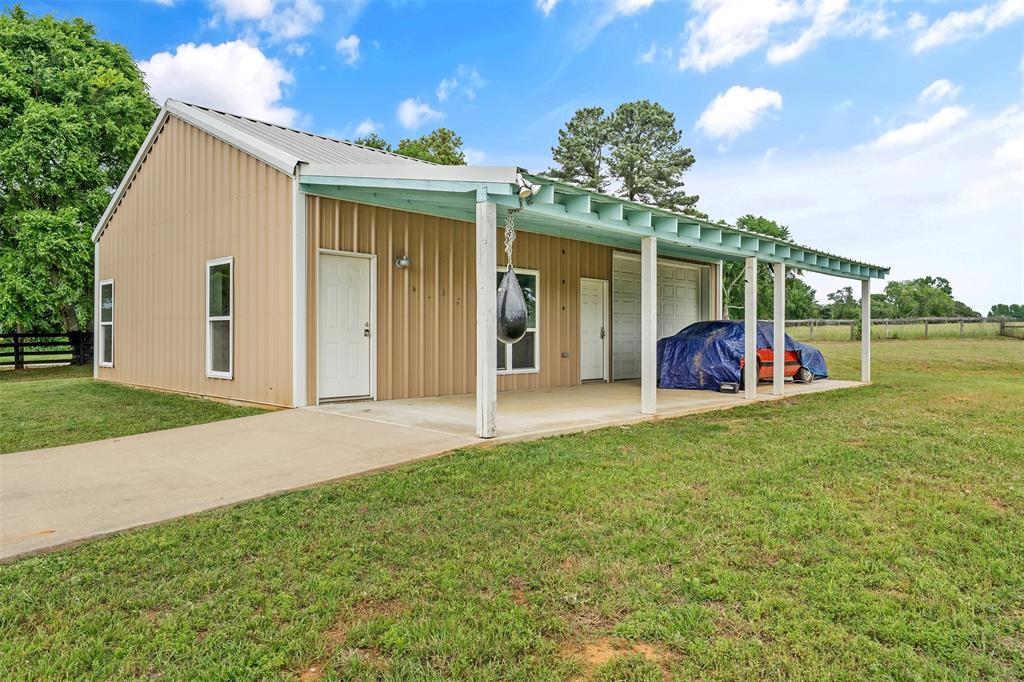 20389 County Road 178 Flint, TX 75762 - Photo 37 of 40 Metal-sided building featuring a covered porch, concrete drive, multiple windows, and a roll-up door