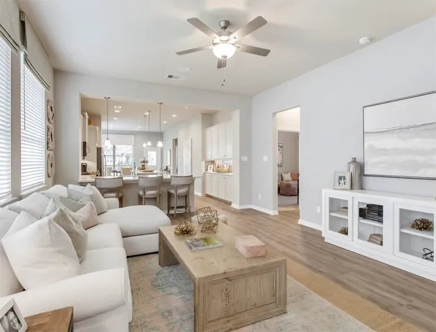 a living room with furniture wooden floor and a large window