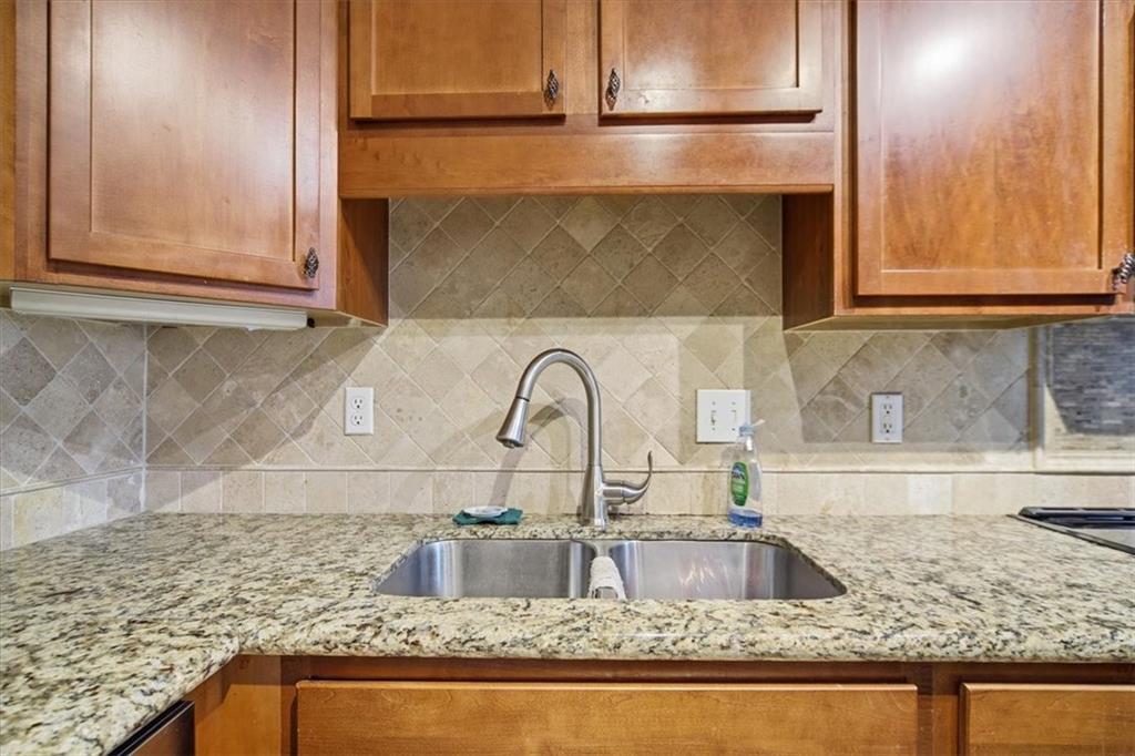 115 Winding River Drive, Unit B Atlanta, GA 30350 - Photo 13 of 32 a kitchen with granite countertop a sink and a wooden cabinets