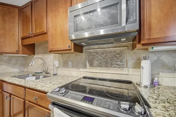 a kitchen with granite countertop a stove and a sink
