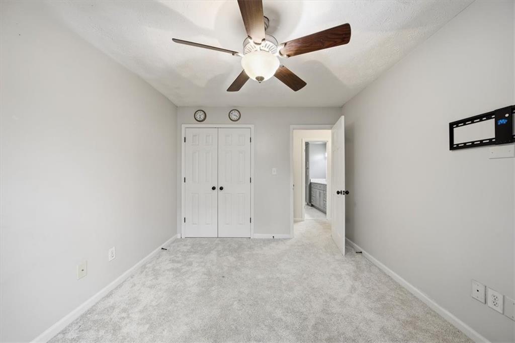 115 Winding River Drive, Unit B Atlanta, GA 30350 - Photo 24 of 32 an empty room with chandelier fan and windows