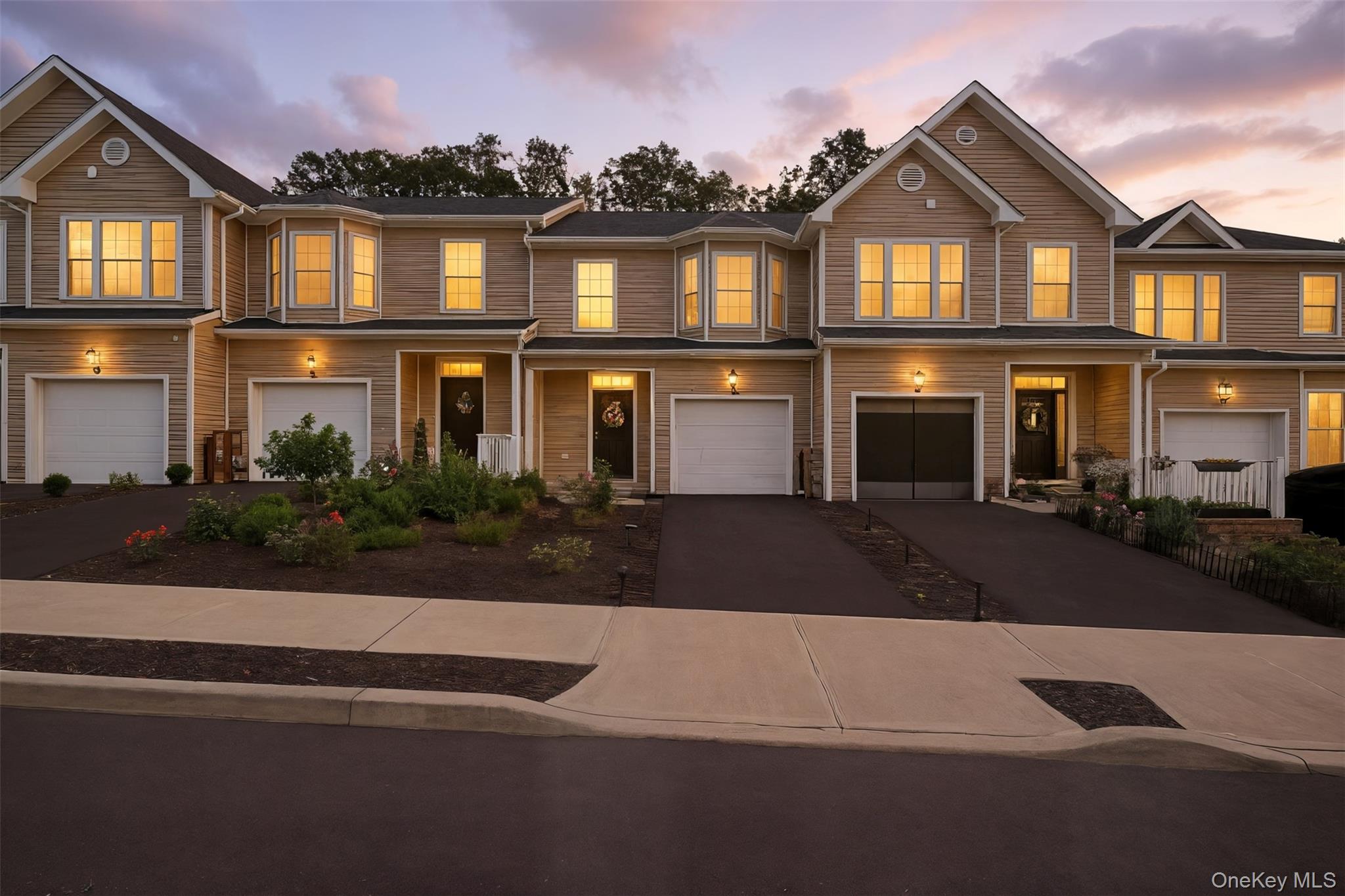 Multi unit property featuring an attached garage and driveway