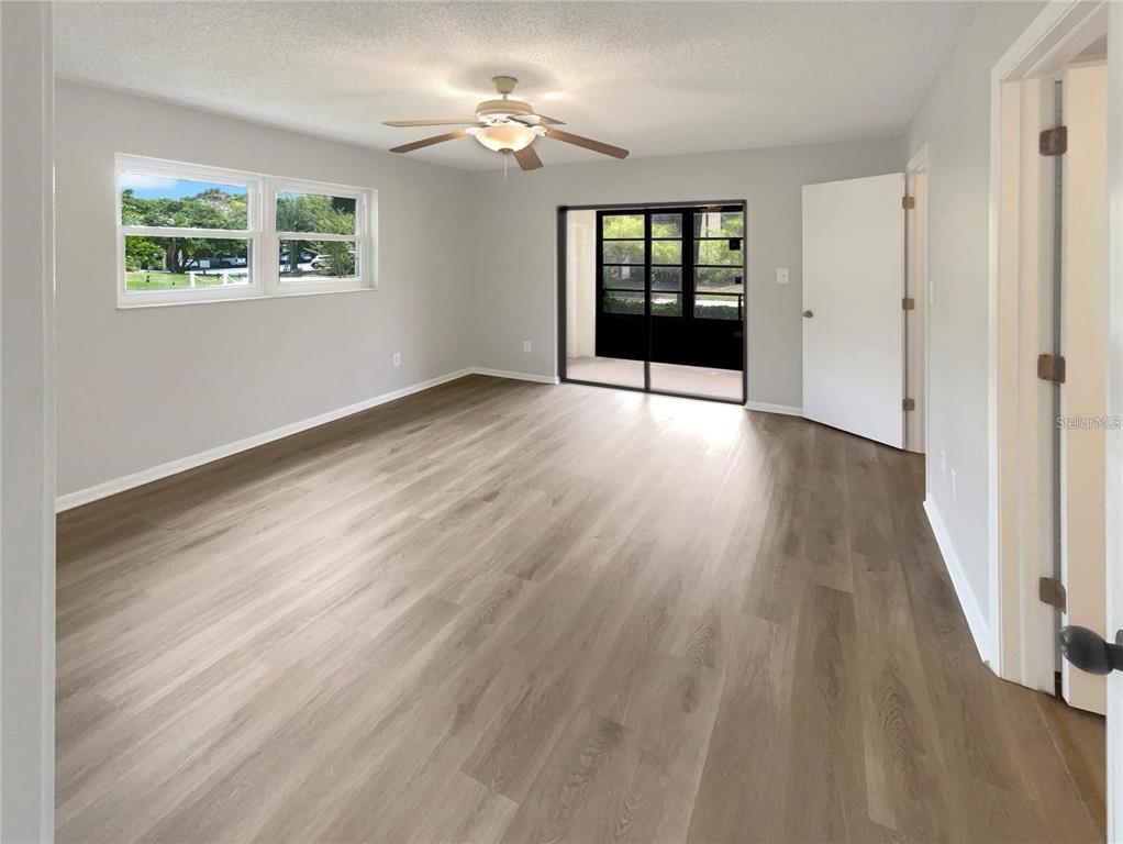 1003 Hammock Pine Boulevard, Unit 1003 Clearwater, FL 33761 - Photo 11 of 28 a view of an empty room with wooden floor and a window