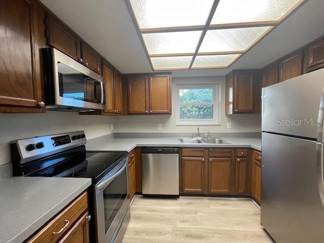 1003 Hammock Pine Boulevard, Unit 1003 Clearwater, FL 33761 - Photo 12 of 28 a kitchen with stainless steel appliances granite countertop a stove a sink dishwasher a refrigerator and a microwave oven