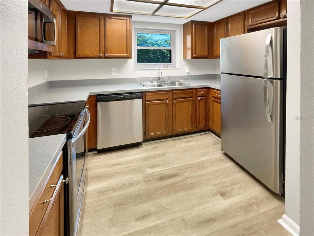 1003 Hammock Pine Boulevard, Unit 1003 Clearwater, FL 33761 - Photo 10 of 28 a kitchen with stainless steel appliances granite countertop a refrigerator sink and cabinets