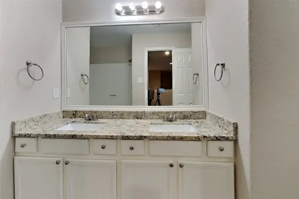 a bathroom with a granite countertop sink and a mirror