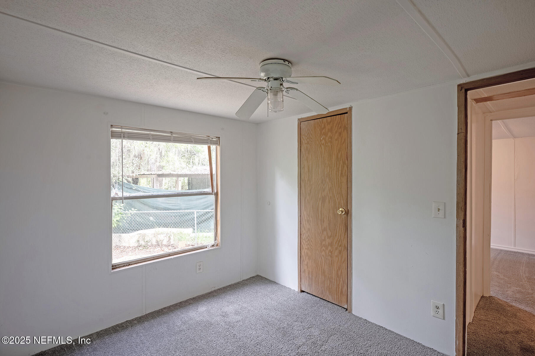 8105 Colee Cove Road St. Augustine, FL 32092 - Photo 35 of 44 a view of an empty room with chandelier fan and fire place