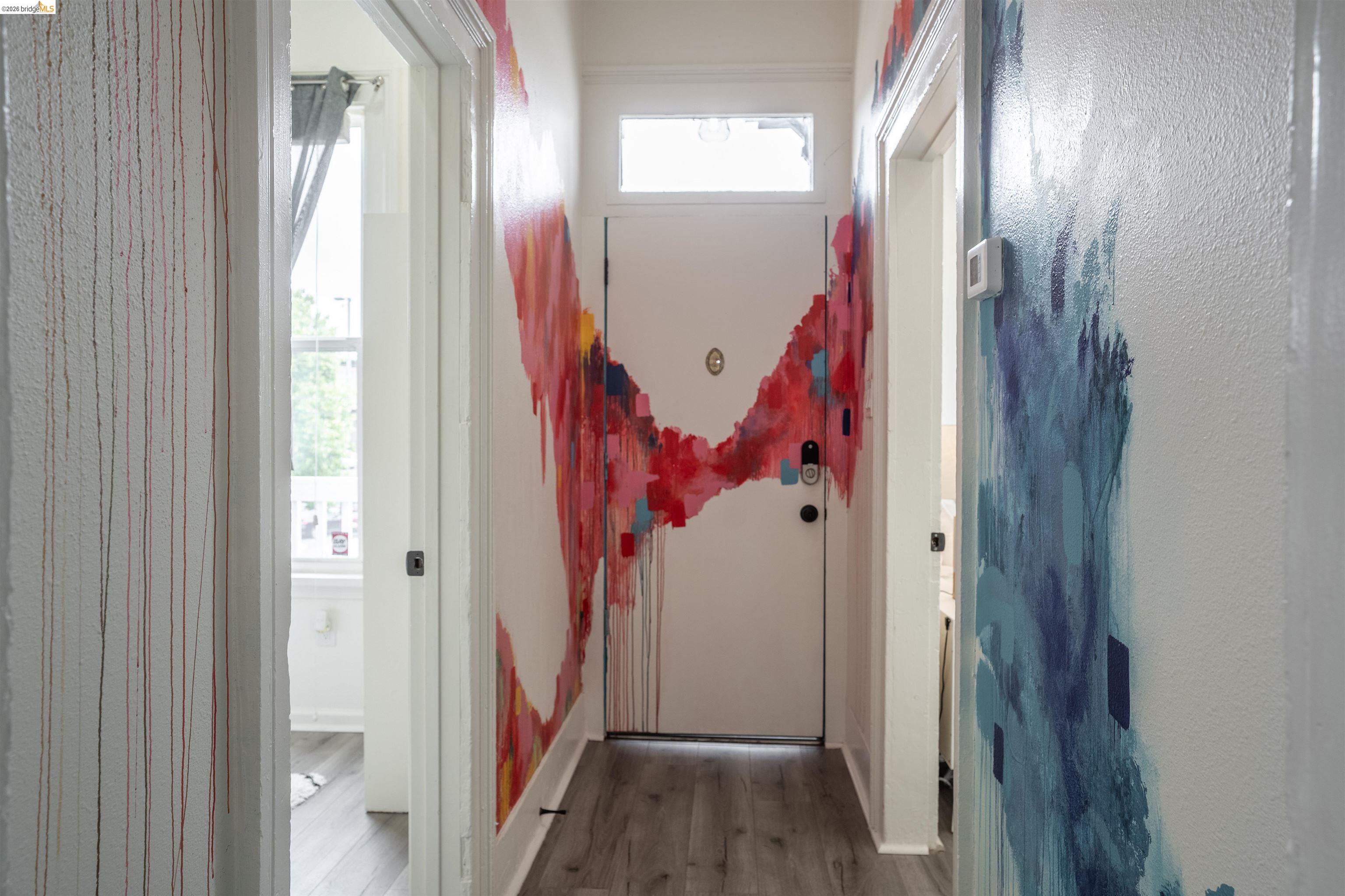 527 Chester Street Oakland, CA 94607 - Photo 27 of 47 527 (Upstairs) All art done by local Oakland artist Good Mother Gallery - Doorway to outside featuring wood finished floors and baseboards