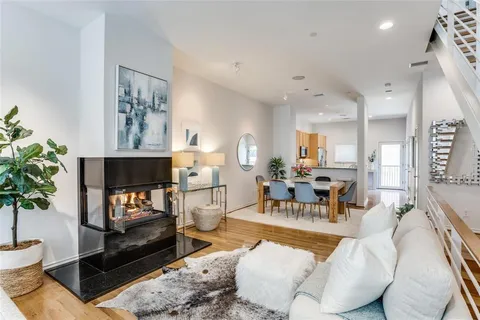 a living room with furniture a potted plant and a fireplace