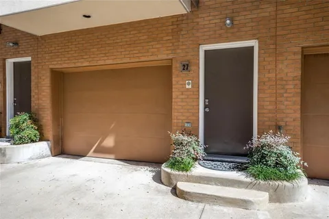 a front view of a house with a yard and large trees
