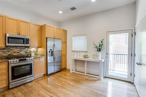 a kitchen with stainless steel appliances a stove a refrigerator and a sink