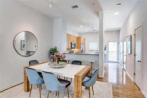 a dining room with furniture a mirror and wooden floor