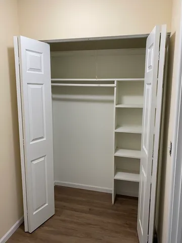 a view of walk in closet with empty racks