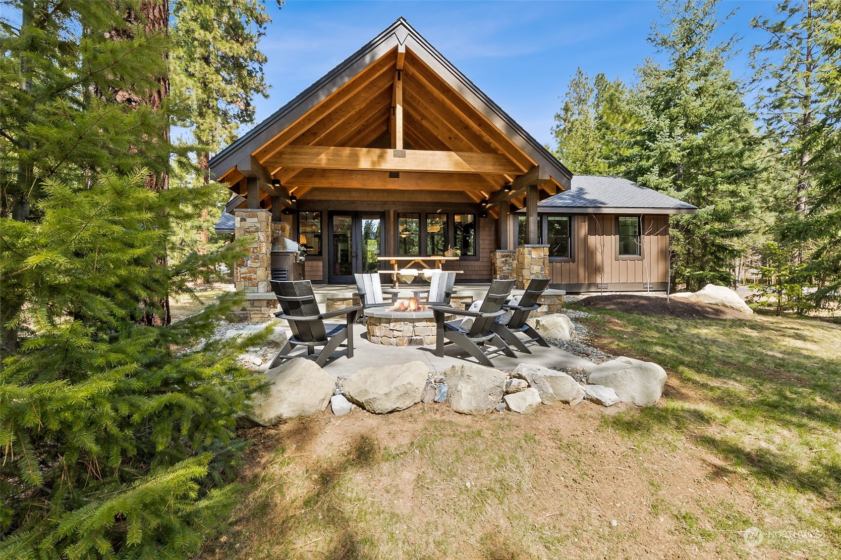 677 Larkspur Loop Cle Elum, WA 98922 - Photo 26 of 38 a backyard of a house with table and chairs under an umbrella